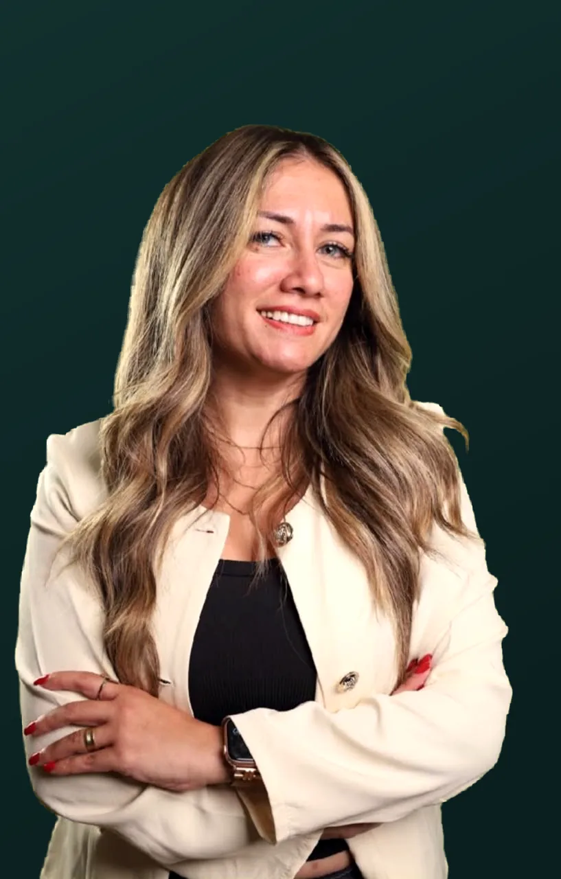 Studio portrait of Dr. Maggy Maher, arms crossed, wearing a cream blazer.