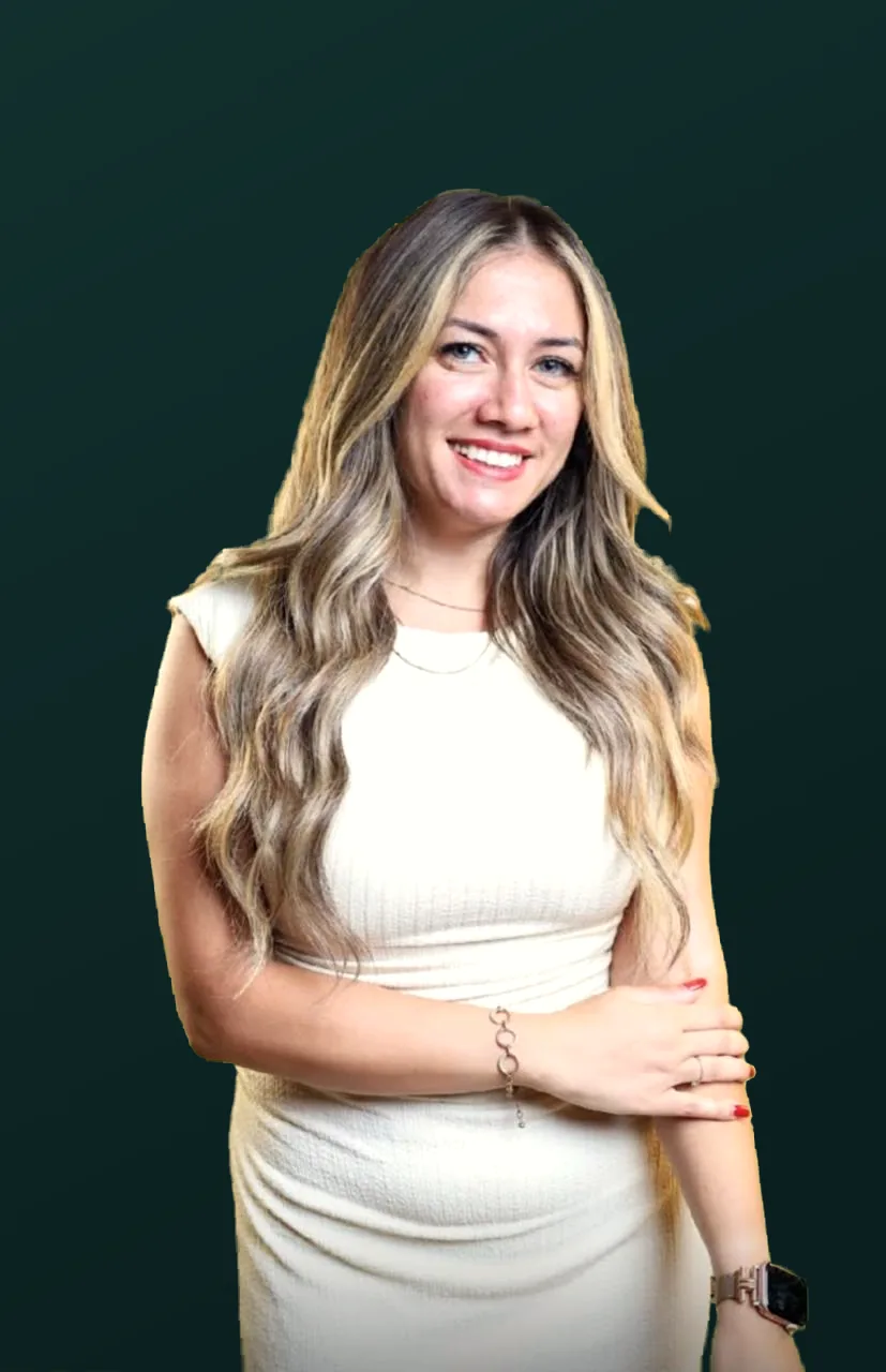 Dr. Maggy Maher in a white dress, smiling toward the camera.