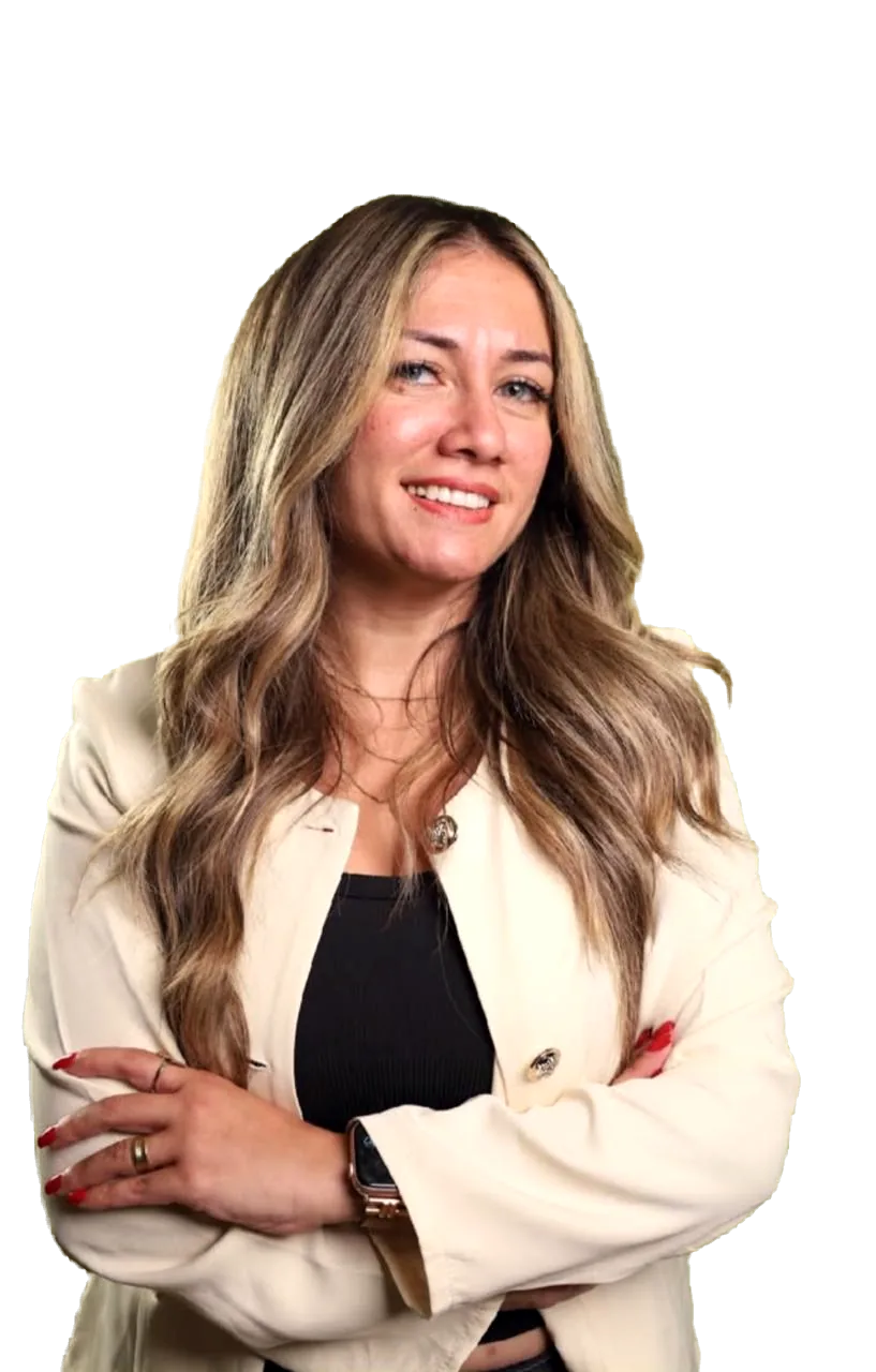 Dr. Maggy Maher, arms crossed, wearing a cream blazer over a black top.